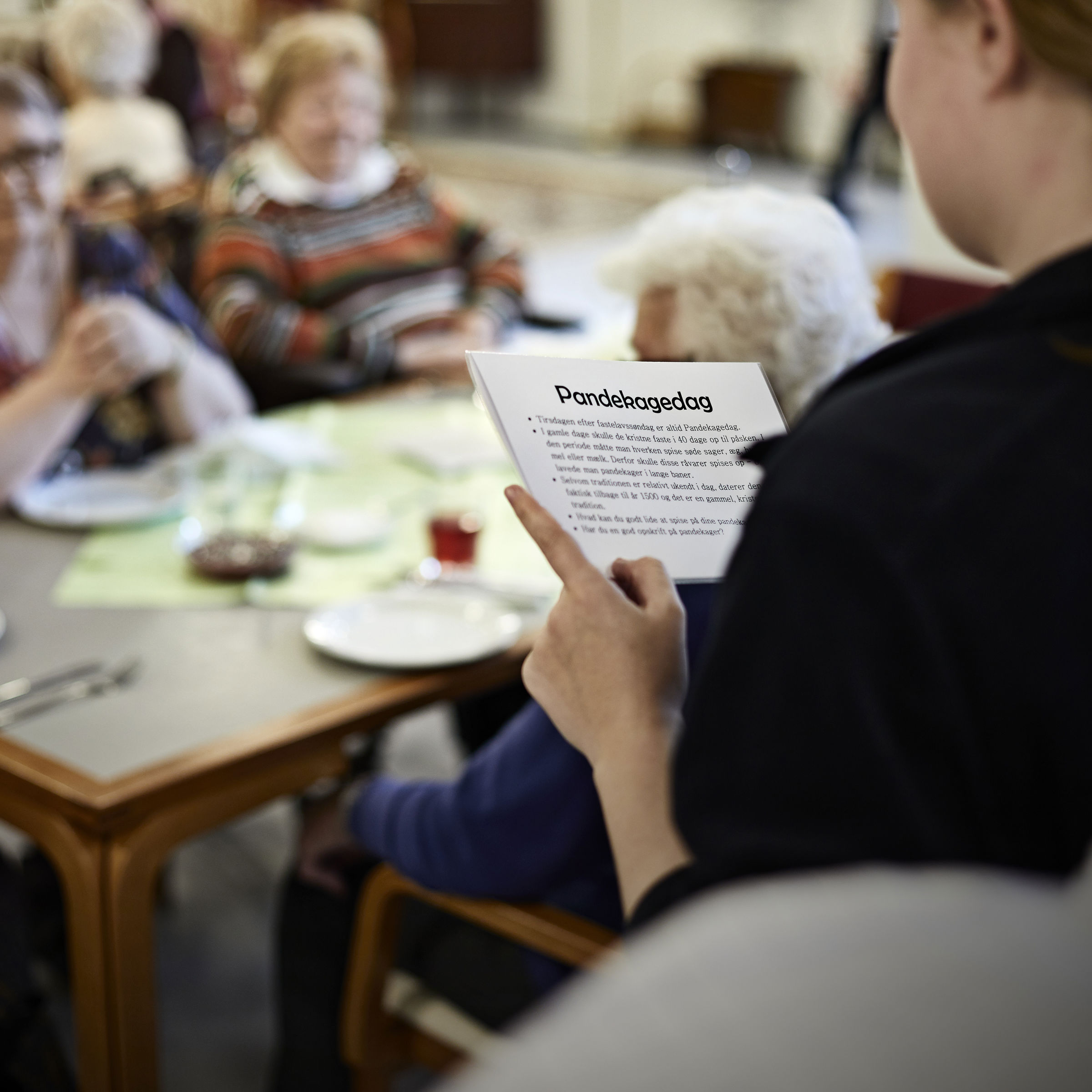 Ældre har fællesspisning og sidder med kort om Pandekagedag fra mærkedagkassen
