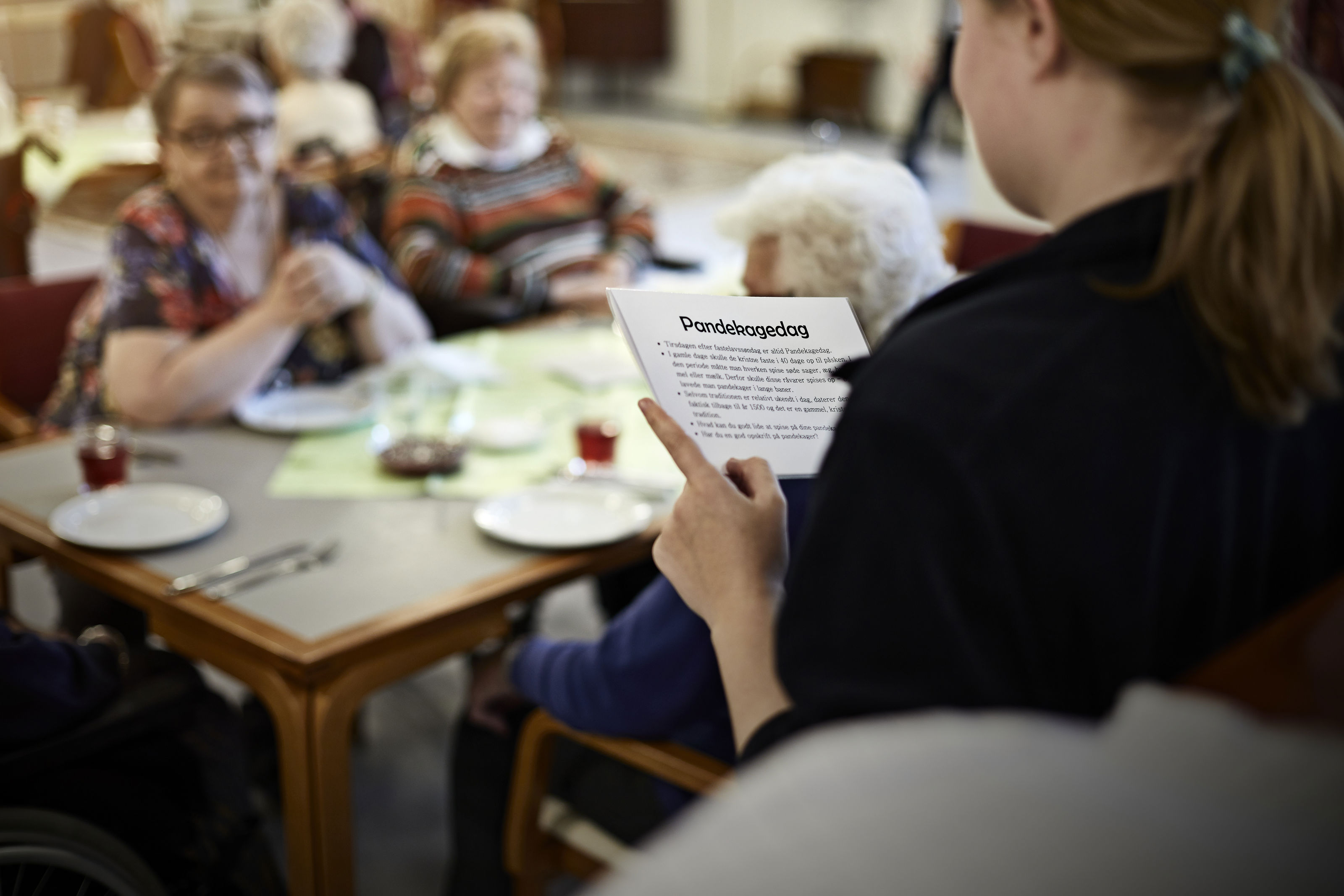 Ældre har fællesspisning og sidder med kort om Pandekagedag fra mærkedagkassen