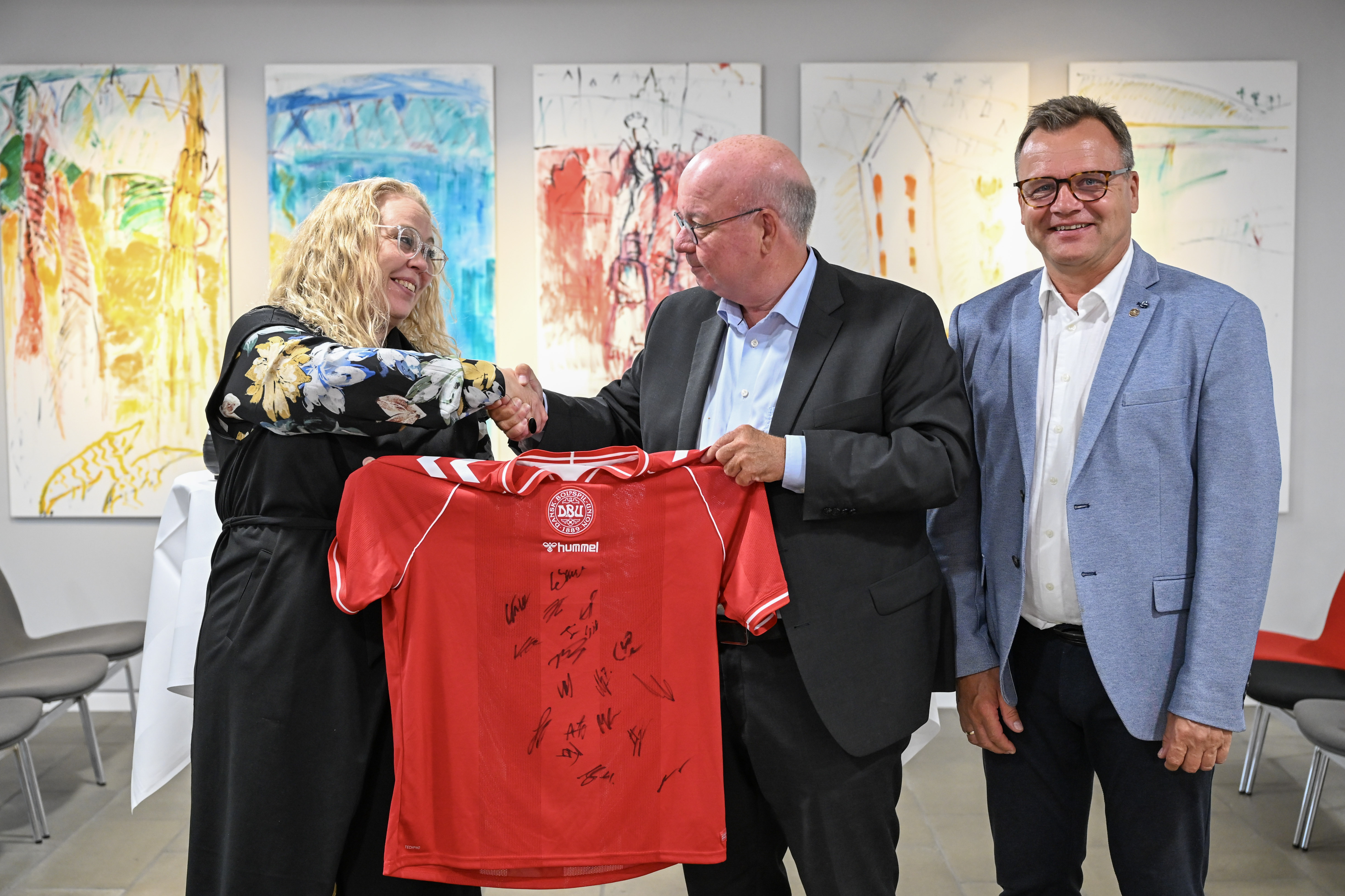 Borgmester i Randers Kommune, Rosa Lykke Yde, formand for DBU, Jesper Møller og formand DBU Jylland, Ole Ladefoged skriver under på aftalen (på foto fra venstre til højre). Inden da modtog borgmesteren en signeret landsholdtrøje i gave af DBU.  Foto: Randers Kommune
