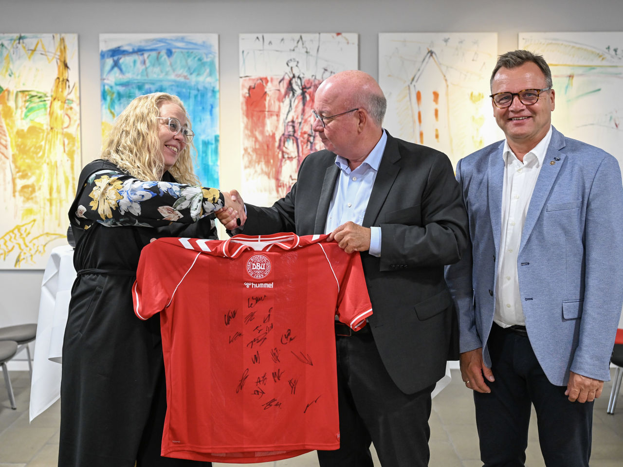Borgmester i Randers Kommune, Rosa Lykke Yde, formand for DBU, Jesper Møller og formand DBU Jylland, Ole Ladefoged skriver under på aftalen (på foto fra venstre til højre). Inden da modtog borgmesteren en signeret landsholdtrøje i gave af DBU. Foto: Randers Kommune